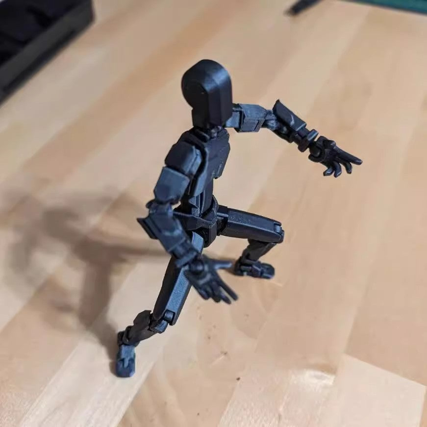 Orange 3D-printad robotfigur i pose
