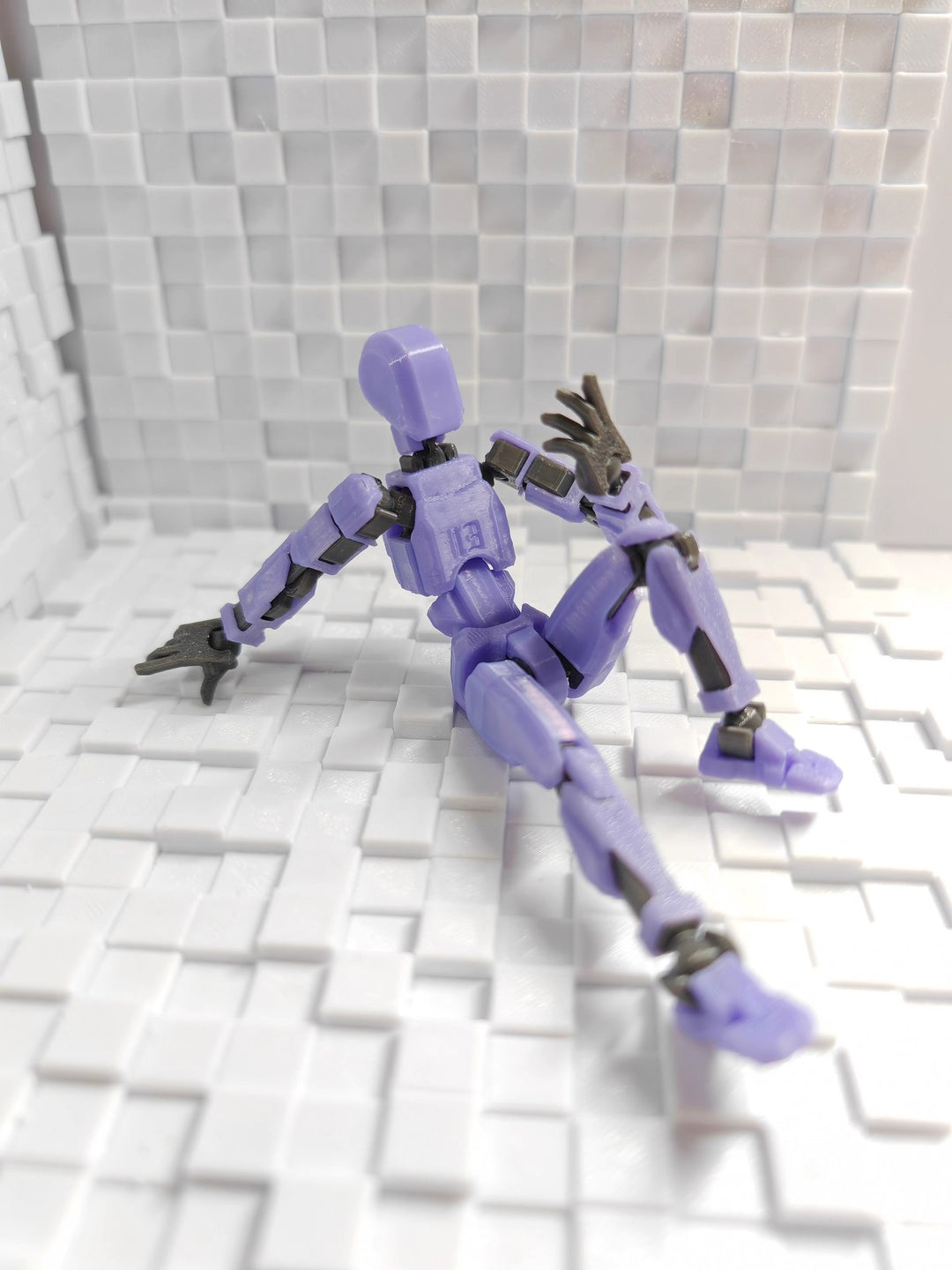 Orange 3D-printad robotfigur i pose