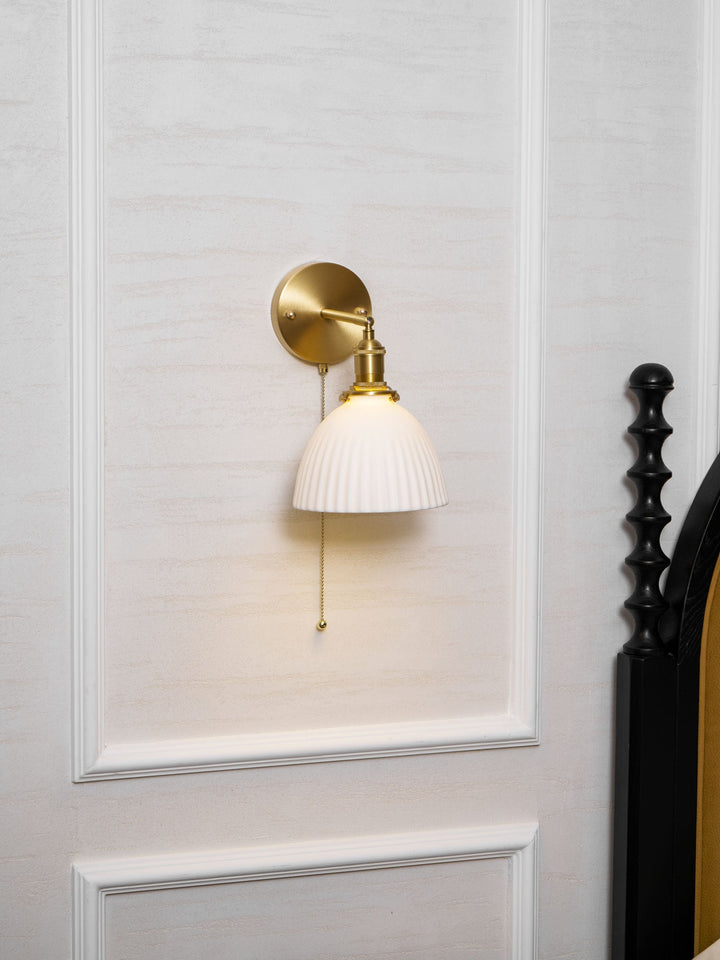Vägglampa i keramik med plissering i mässing