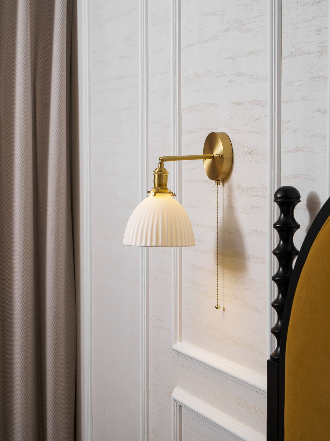 Vägglampa i keramik med plissering i mässing