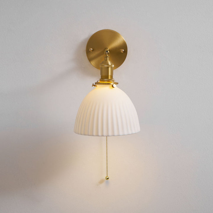 Vägglampa i keramik med plissering i mässing