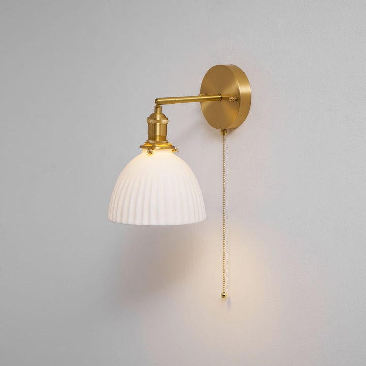 Vägglampa i keramik med plissering i mässing