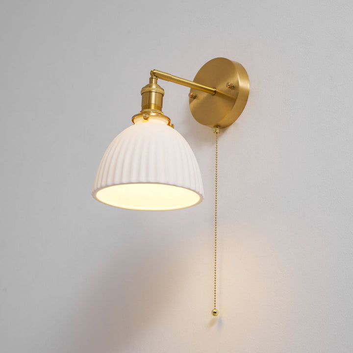 Vägglampa i keramik med plissering i mässing
