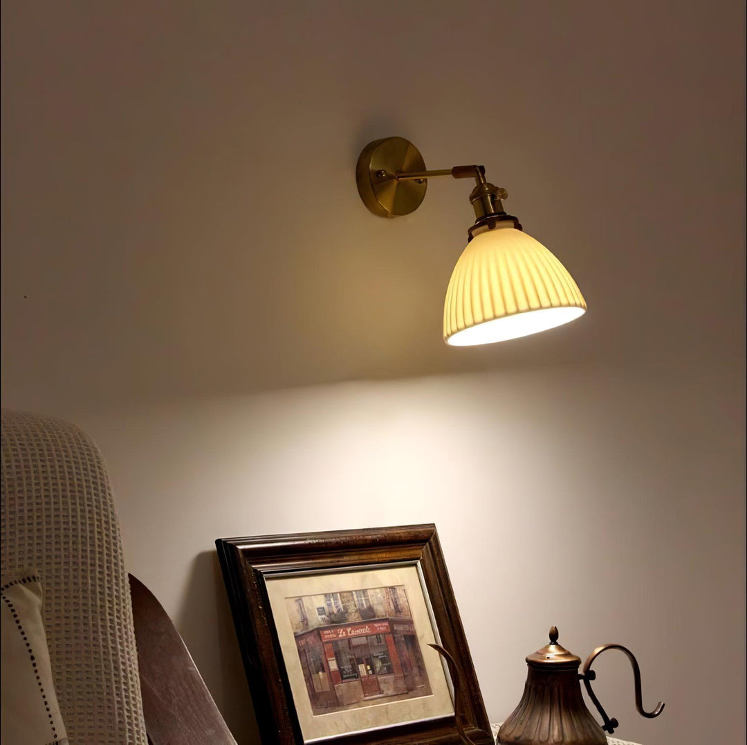Vägglampa i keramik med plissering i mässing