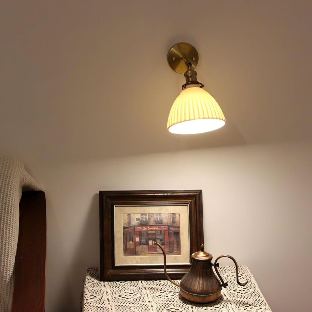 Vägglampa i keramik med plissering i mässing