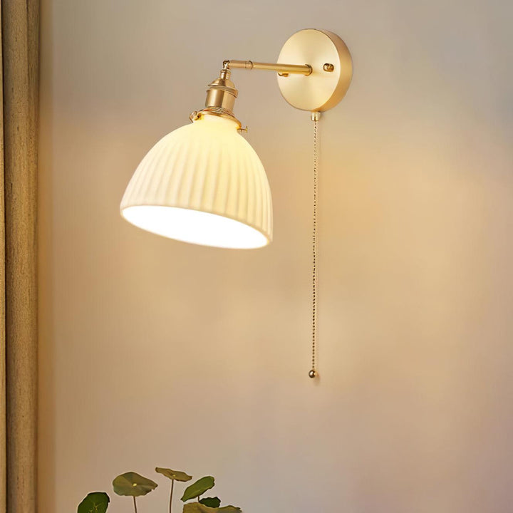 Vägglampa i keramik med plissering i mässing