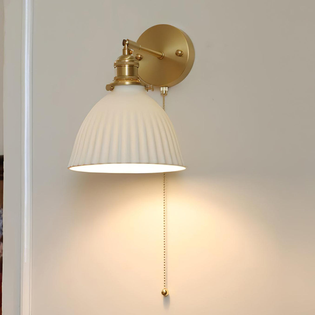 Vägglampa i keramik med plissering i mässing