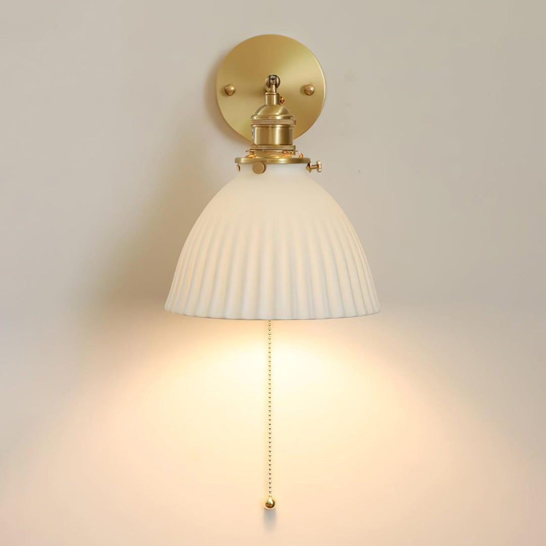 Vägglampa i keramik med plissering i mässing