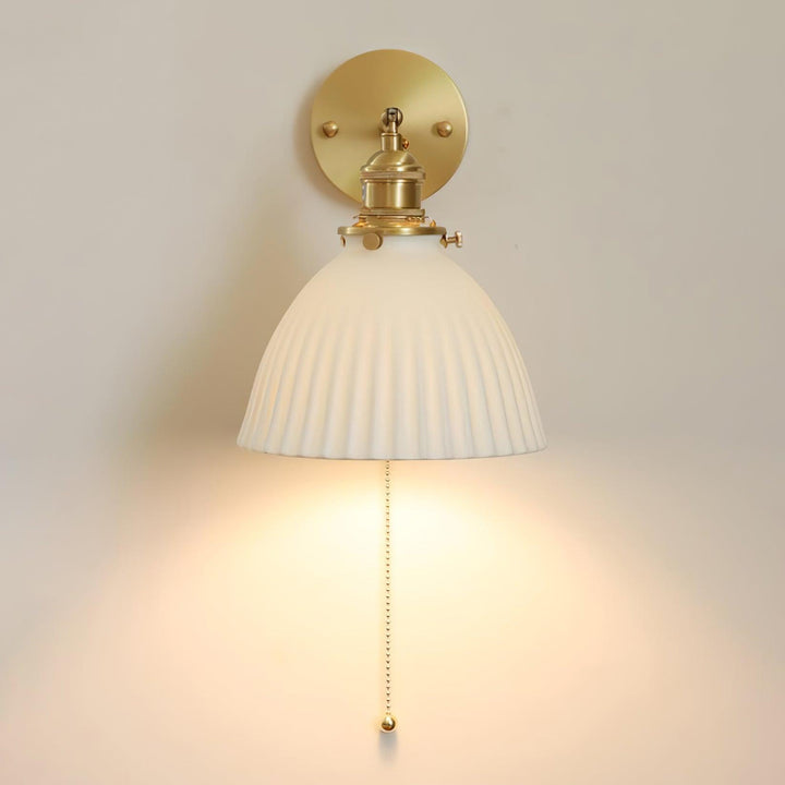 Vägglampa i keramik med plissering i mässing