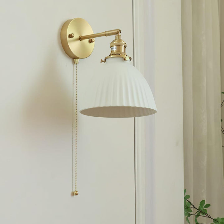 Vägglampa i keramik med plissering i mässing