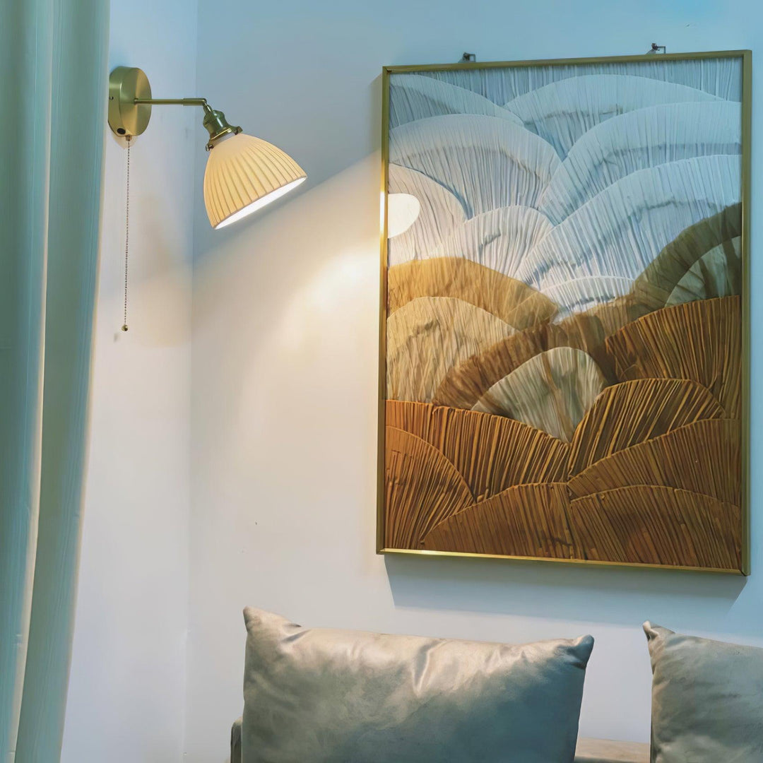 Vägglampa i keramik med plissering i mässing