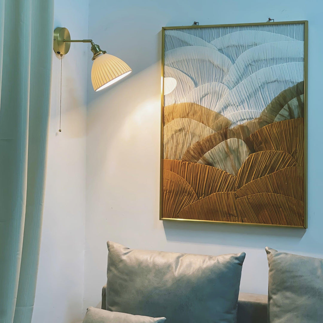 Vägglampa i keramik med plissering i mässing