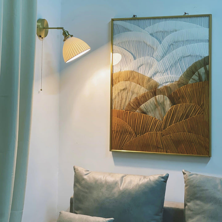 Vägglampa i keramik med plissering i mässing
