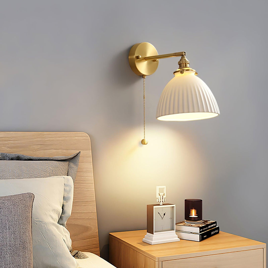 Vägglampa i keramik med plissering i mässing