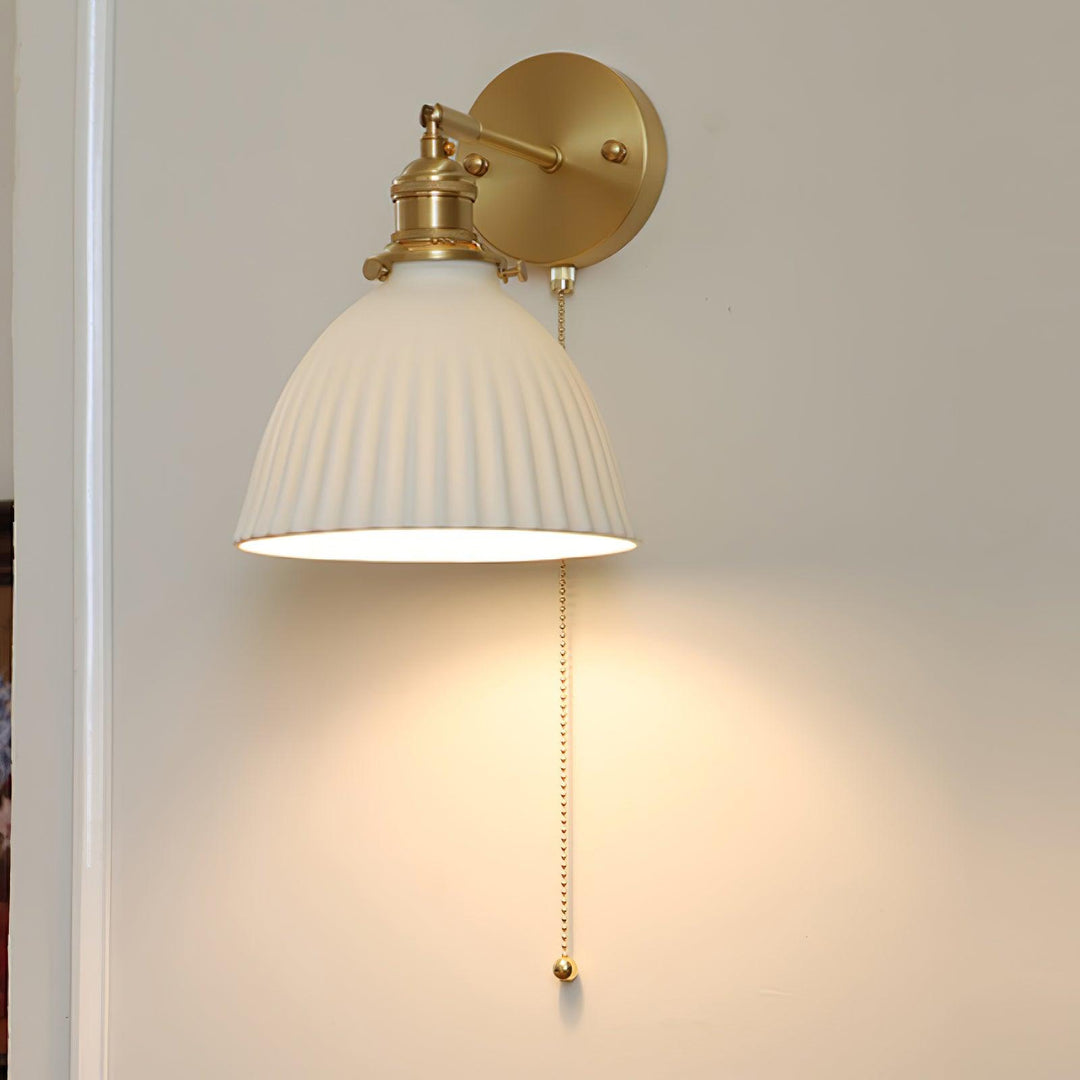 Vägglampa i keramik med plissering i mässing