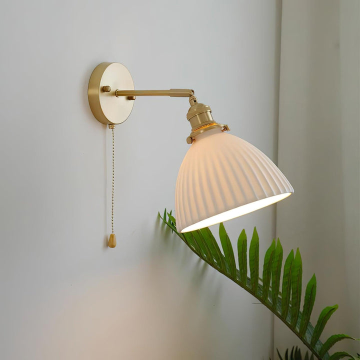 Vägglampa i keramik med plissering i mässing