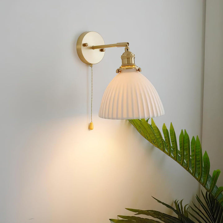 Vägglampa i keramik med plissering i mässing