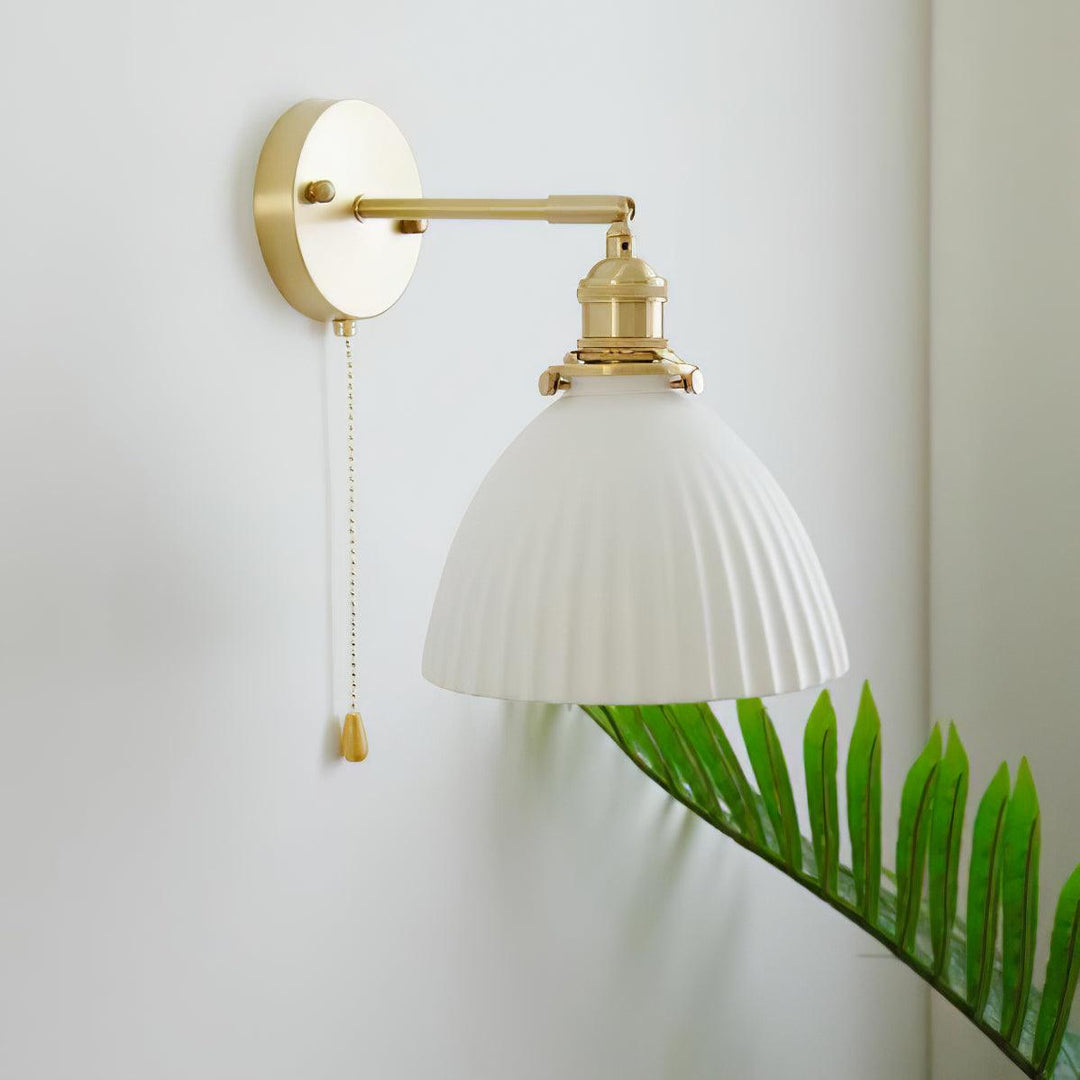 Vägglampa i keramik med plissering i mässing
