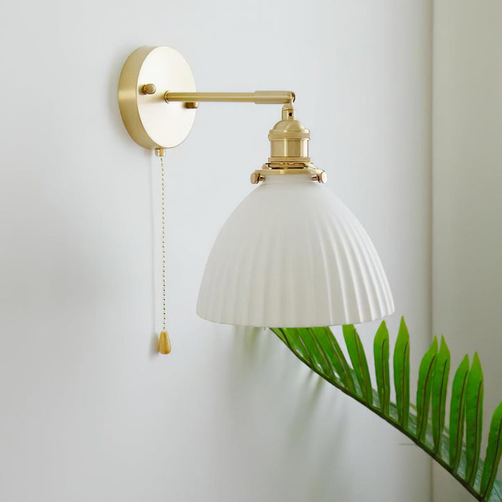 Vägglampa i keramik med plissering i mässing