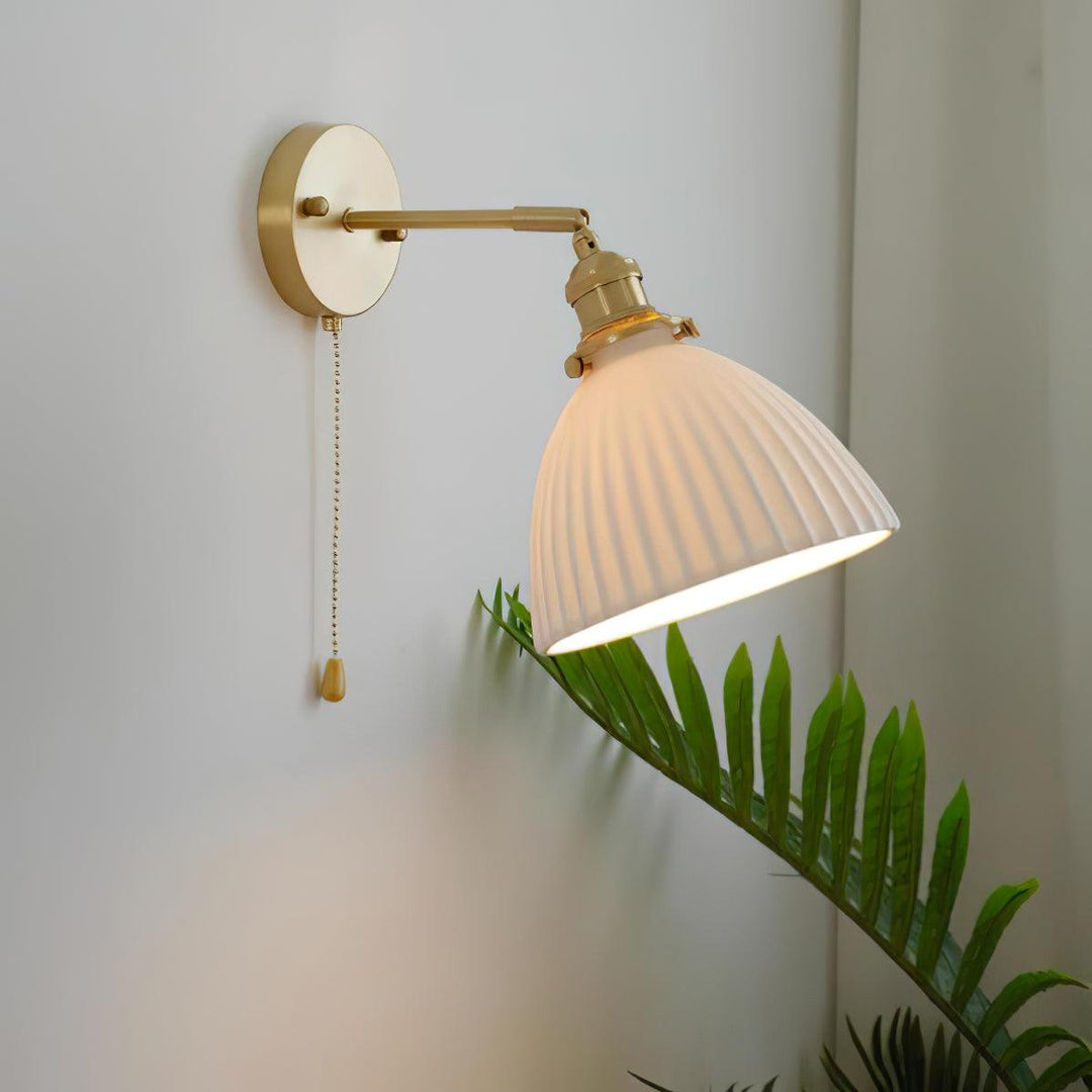Vägglampa i keramik med plissering i mässing