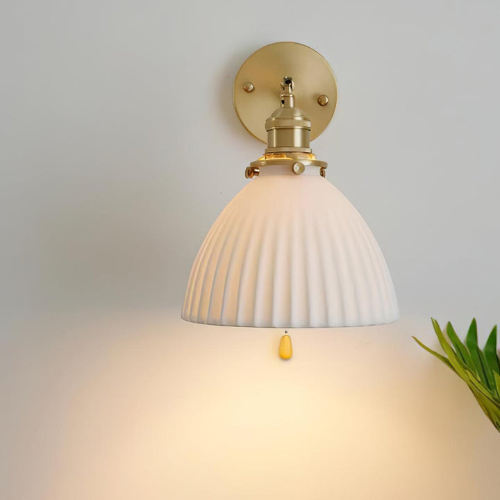 Vägglampa i keramik med plissering i mässing