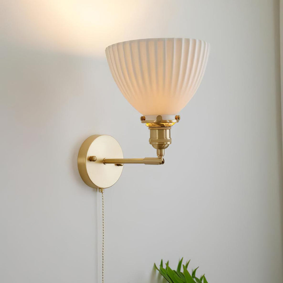 Vägglampa i keramik med plissering i mässing